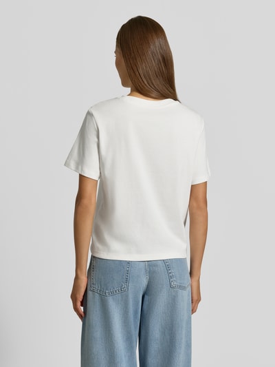 Frauenmodel trägt Regular Fit T-Shirt aus reiner Baumwolle von s.Oliver RED LABEL in Weiß zu blauer Jeans, Ganzkörperansicht Rückansicht.