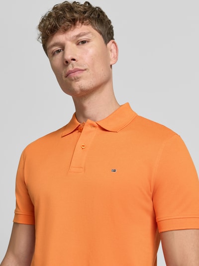 Männermodel trägt Regular Fit Poloshirt mit Stitching van Christian Berg Men in fel oranje, puur katoen, met knoopsluiting, nahaufnahme oberkörper.