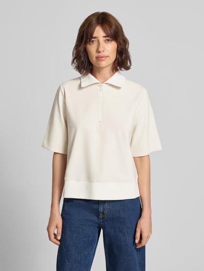 Frauenmodel trägt Sweatshirt mit Stehkragen und 1/2-Arm von Marc Cain, locker geschnittener Baumwoll-Mix in Creme, Ganzkörperansicht von vorne.