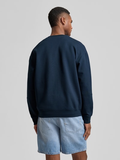 Männermodel trägt Sweatshirt mit Label-Patch Modell 'Juanfrancisco' von JOOP! Collection, dunkelblau, Baumwoll-Mix, Ganzkörperansicht Rückansicht.