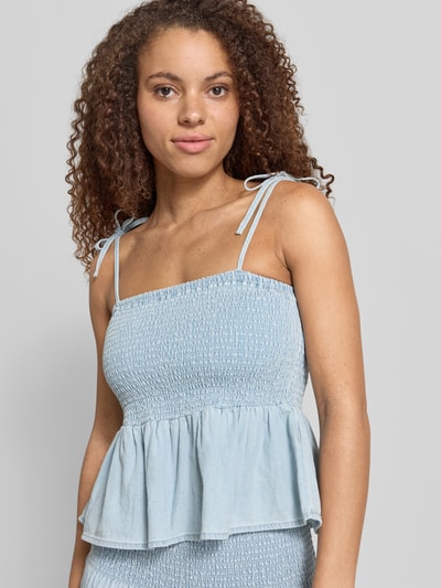Frauenmodel trägt Blusentop mit Smok-Details Modell 'OREGON' von Noisy May, Denim-Optik, Reine Baumwolle, Slim-Fit, Nahaufnahme Oberkörper.