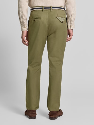 Männermodel trägt Chino mit Gürtel und Eingrifftaschen Modell 'WARREN' von Scotch & Soda in Olivgrün, Baumwoll-Mix, Straight Fit, Ganzkörperansicht Rückansicht.