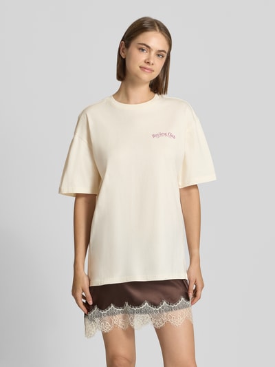 Frauenmodel trägt Oversized Fit T-Shirt aus reiner Baumwolle mit Label-Detail von REVIEW, helle Farbgebung, Print auf der Rückseite, Ganzkörperansicht von vorne.