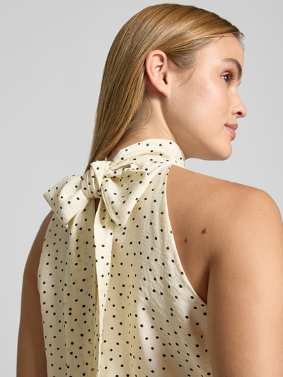 Frauenmodel trägt Blusentop aus Viskose-Mix mit Neckholder Modell 'JOS' von Neo Noir, cremefarben mit schwarzen Punkten, Nahaufnahme Rückenansicht.