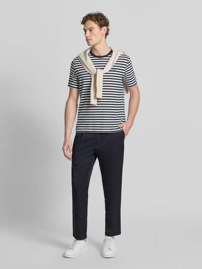 Männermodel trägt Tapered Fit Hose mit Gesäßtaschen von MCNEAL in Dunkelblau, Baumwoll-Anteil, Material-Mix, Drapierungen, Ganzkörperansicht von vorne.
