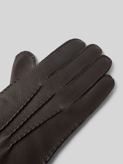Produktfoto, Lederhandschuhe aus echtem Leder Modell 'Garmisch' von Roeckl in dunkelbraun mit Ziernähten und metallic Label-Detail, strukturierte Lederoberfläche.