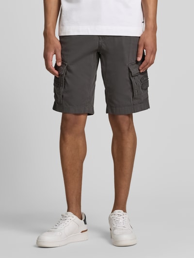 Männermodel trägt Bermudas mit Pattentaschen und Label-Stitchings von PME Legend in Grau mit Eingrifftaschen, Knopf-Reißverschluss, Ganzkörperansicht von vorne.