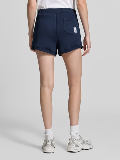 Frauenmodel trägt Regular Fit Sweatshorts mit Logo-Applikation von Lacoste in Optik: Unifarben, Sweat, Ganzkörperansicht Rückansicht.