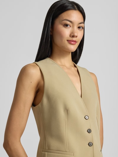 Modelka kobieca nosi kamizelkę Slim Fit Weste mit einreihiger Knopfleiste Modell 'C_Javesta1' od BOSS Orange w kolorze beżowym, gładka tekstura, zbliżenie na górną część ciała