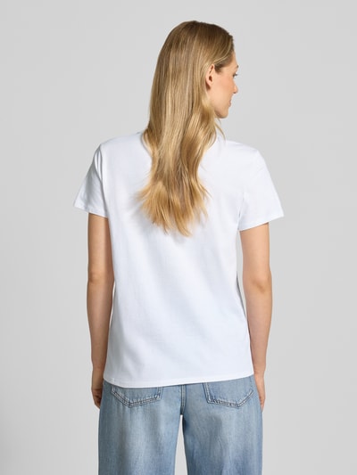 Modelka kobieca nosi białe T-Shirt aus reiner Baumwolle Modell 'CLINK EASY TEE' od Guess o prostym kroju z okrągłym dekoltem, widok całej sylwetki z tyłu.