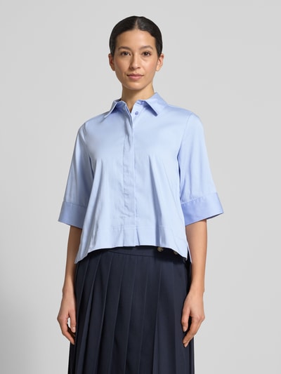 Modelka kobieca ma na sobie Boxy Fit Bluse mit verdeckter Knopfleiste od Milano Italy z bawełnianej mieszanki ze stretchem, jasnoniebieska, koszulowy kołnierzyk, długość tyłu 54 cm, długość rękawa 34 cm, widok całej sylwetki z przodu.
