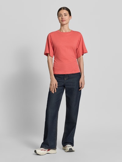 Frauenmodel trägt T-Shirt mit 1/2-Arm und Raffungen von Jake*s Casual aus Reine Baumwolle in Koralle, körpernahe Passform, Rundhalsausschnitt, Rückenlänge bei Größe S 54 cm, Ganzkörperansicht von vorne.