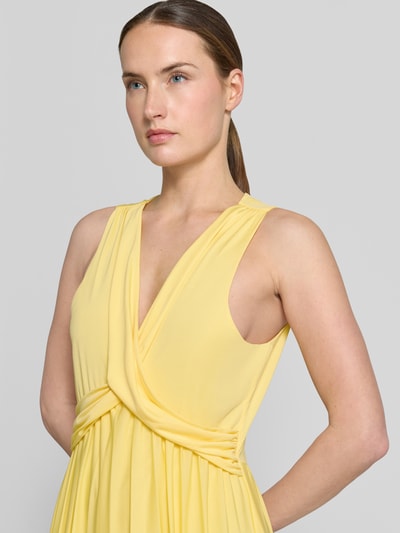 Frauenmodel trägt Abendkleid mit V-Ausschnitt Modell 'Amanda' von GUIDO MARIA KRETSCHMER WOMAN aus gelbem Satin mit Taillierter Schnitt, Raffungen und Rückseitigem Schlüsselloch-Ausschnitt, Nahaufnahme Oberkörper.