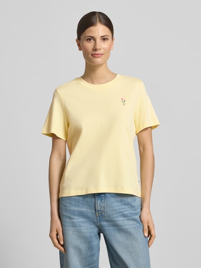Frauenmodel trägt Regular Fit T-Shirt aus reiner Baumwolle von s.Oliver RED LABEL in Gelb mit Motiv-Print, Rundhals, kurzarm, Cropped-Länge, Jersey-Textur, Ganzkörperansicht von vorne.