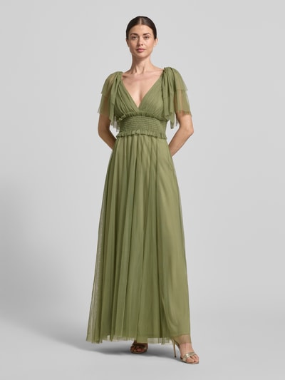Frauenmodel trägt Maxikleid mit V-Ausschnitt und Taillenband von LACE & BEADS aus grünem Tüll, taillierter Schnitt, Ganzkörperansicht von vorne.