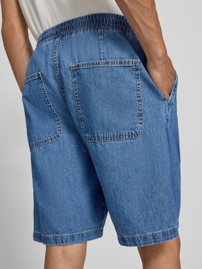 Mężczyznamodel nosi szorty z elastycznym pasem i trokiem model 'TONY' od Jack & Jones, bawełna, krój straight fit, kieszenie z tyłu, szerokość w rozmiarze M 43 cm, długość wewnętrzna nogawki w rozmiarze M 20 cm, widok z tyłu