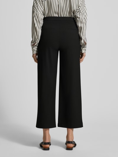 Frauenmodel trägt Wide Fit Schlupfhose mit Viskose-Anteil Modell 'Palina' von Raffaello Rossi in Schwarz mit Crêpe-Struktur, Ganzkörperansicht Rückansicht.
