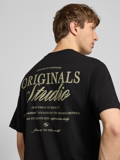 Männermodel trägt T-Shirt mit Statement-Print Modell 'NORREBRO' von Jack & Jones, Reine Baumwolle, Gerader-Schnitt, Nahaufnahme Rückansicht.
