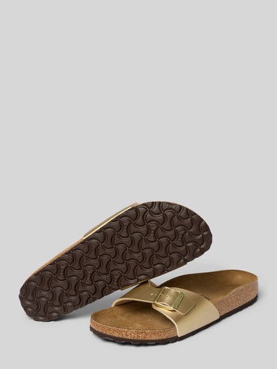 Produktfoto, Slipper mit offener Ferse Modell 'Madrid' von Birkenstock in Gold mit brauner Laufsohle, abgerundete Passform, Logo-Detail, Absatzhöhe 3 cm, strukturierte Oberflächen und glatte Metallschnalle.