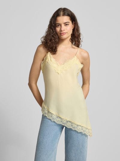 Frauenmodel trägt Top aus Satin mit Spitzenbesatz von REVIEW, gelb, Asymmetrischer-Look, V-Ausschnitt, Spaghettiträger, Rückenlänge 54 cm, Ganzkörperansicht von vorne.