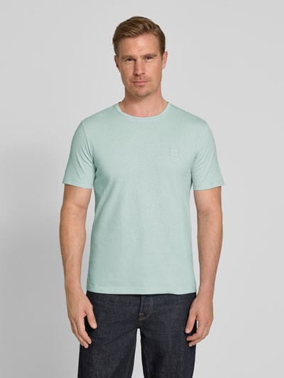 Männermodel trägt Regular Fit T-Shirt aus reiner Baumwolle Modell 'TALES' von BOSS Orange in Optik: Unifarben mit Label-Patch, Rundhals-Ausschnitt, Ärmelform: Kurzarm, Materialverarbeitung: Jersey, Ganzkörperansicht von vorne.