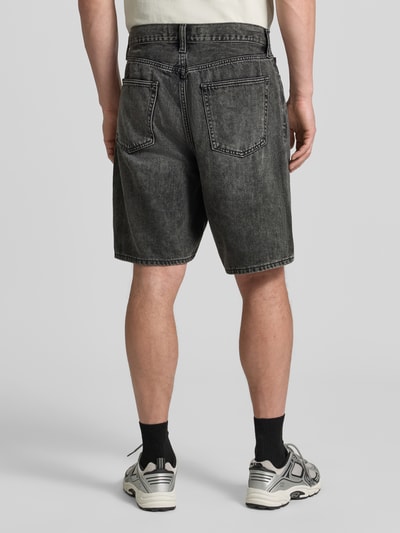 Männermodel trägt Bermudas im 5-Pocket-Design von GAP, Wide-Fit, aus Baumwoll-Lyocell-Mix, dezentes Grau, Ganzkörperansicht Rückansicht, Bundweite 41 cm, Innenbeinlänge 23 cm.