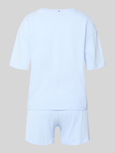 Vrouwenmodel draagt Regular Fit Pyjama aus reiner Baumwolle van TOMMY HILFIGER in effen lichtblauw katoen met logoborduring, elastische logoband, ronde hals, korte mouwen, en zijzakken, volledig katoen, tweedelig, Ganzkörperansicht Rückansicht.