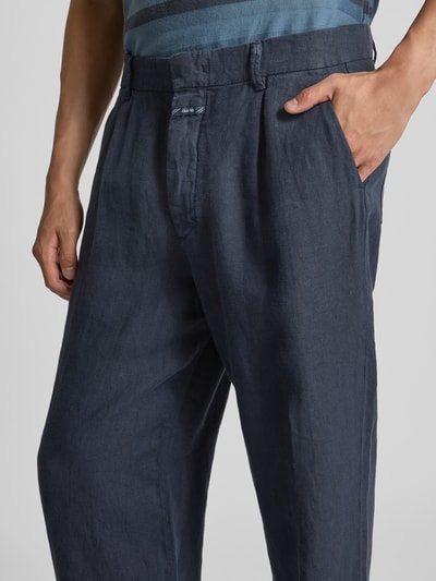 Männermodel trägt Straight Fit Leinenhose von Closed in Dunkelblau, reine Leinenstruktur, seitliche Taschen, Nahaufnahme Oberkörper.