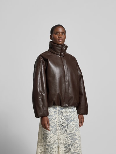 Frauenmodel trägt Oversized Jacke mit Leder-Anteil von Anine Bing, dunkelbrauner Material-Mix, gefütterter Stehkragen, Ganzkörperansicht von vorne, Rückenlänge 61 cm, Brustweite 64 cm, Ärmellänge 56 cm, durchgehender Verschluss mit Abdeckleiste, überschnittene Schultern.