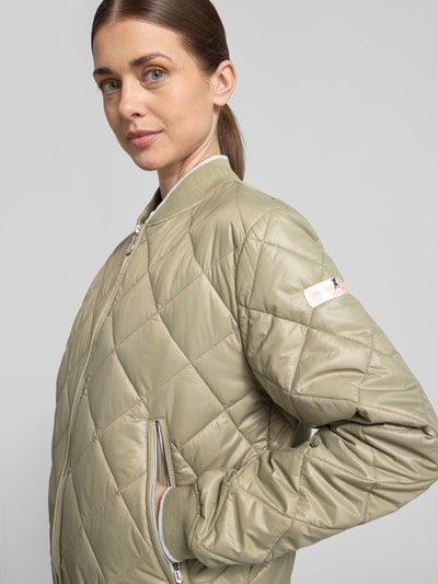 Kobieta modelka nosi Steppjacke mit Zweiwege-Reißverschluss Modell 'BOY' von Frieda & Freddies, kolor jasnobeżowy, pikowana struktura, zamek błyskawiczny, krój regular fit, stebnowana faktura, stójka, długość tyłu w rozmiarze 36: 20 cm, szerokość ramion w rozmiarze 36: 16 cm, szerokość w biuście w rozmiarze 36: 21 cm, długość rękawa w rozmiarze 36: 24 cm, kieszenie na zamek, zbliżenie na górną część przodu