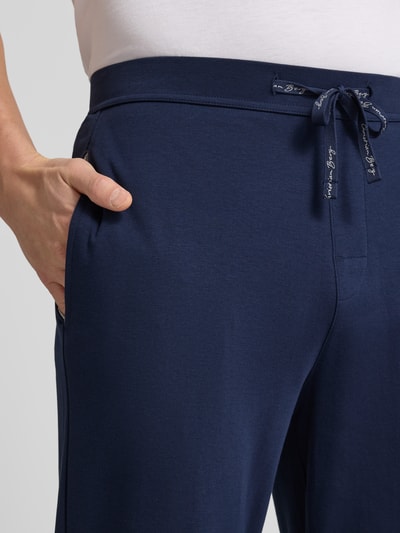 Männermodel trägt dunkelblaue Sweatpants mit elastischem Bund von Christian Berg Men aus reiner Baumwolle, Nahaufnahme Oberkörper.