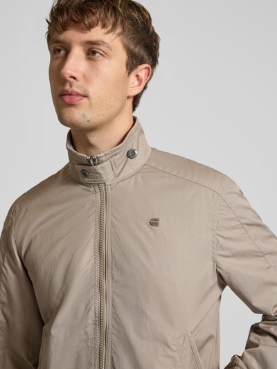 Männermodel trägt Jacke mit Stehkragen und Reißverschluss von G-Star Raw aus Baumwoll-Mix in Beige, Regular Fit, Nahaufnahme Oberkörper.