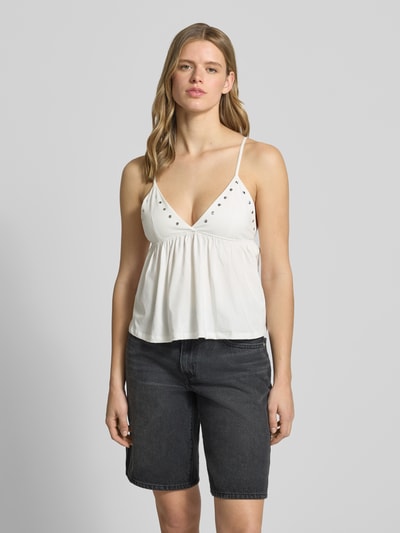 Kobiece modelka nosi Trägertop mit V-Ausschnitt und Nieten od Gina Tricot, biała bawełna, krój regular fit, cienkie ramiączka, długość tyłu 21 cm w rozmiarze S, dekolt w serek, nity, przód w całości, z przodu