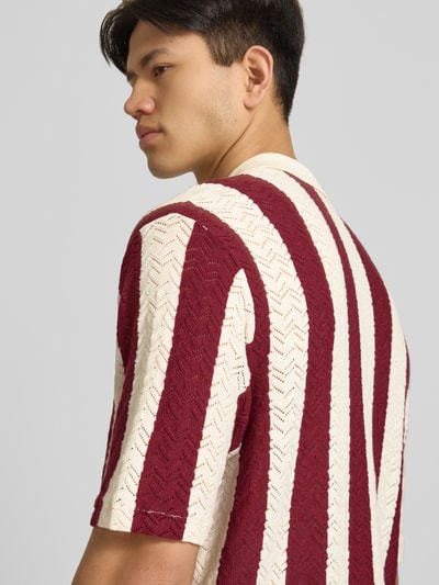 Männermodel trägt Regular Fit Poloshirt mit Knopfleiste Modell 'TYLER' von Jack & Jones, Baumwoll-Mix, creme-rot, Nahaufnahme Rückansicht.