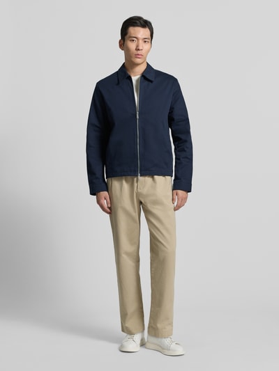 Männermodel trägt Regular Fit Blouson mit Reißverschluss Modell 'DOBBY' von CK Calvin Klein in Dunkelblau, Ganzkörperansicht von vorne. Herren Blouson mit Zweiwege-Reißverschluss, Umlegekragen, Eingrifftaschen, Rückenlänge 57 cm, Schulterbreite 52 cm, Brustweite 44 cm, Ärmellänge 67 cm.