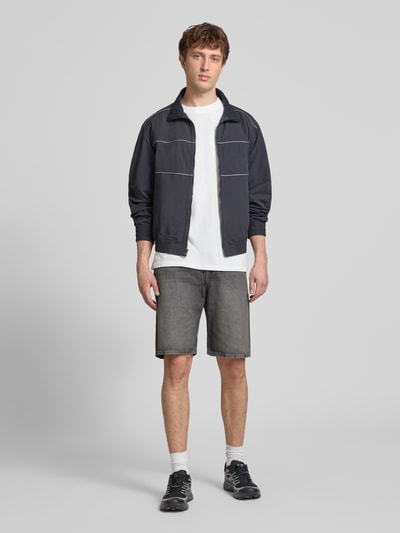 Männermodel trägt Baggy Fit Jeansshorts mit Eingrifftaschen Modell 'ALEX' von Jack & Jones aus Reine Baumwolle, Grau, Ganzkörperansicht von vorne. Bundweite 42 cm, Innenbeinlänge 26 cm, Herren Jeansshorts.