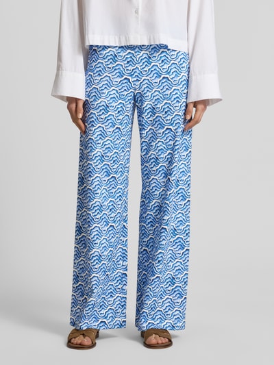 Frauenmodel trägt Wide Fit Stoffhose mit elastischem Bund von HERZENS, blau-weißes Wellenmuster, elastischer Material-Mix, Ganzkörperansicht von vorne.