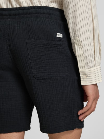 Männermodel trägt Shorts mit Strukturmuster Modell 'AIDEN' von Jack & Jones aus Material-Mix, Detailaufnahme Rückansicht.