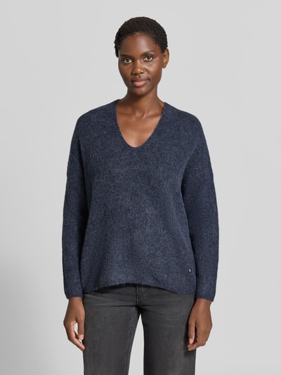 Kobiece modelka nosi sweter z dzianiny z mieszanki wełny i alpaki, krój regular fit, dekolt w serek, model 'THORA' od MOS MOSH, długość tyłu 82 cm, długość rękawów 46 cm, kolor ciemnoniebieski, tekstura miękka, zdjęcie w ujęciu całej sylwetki od przodu.