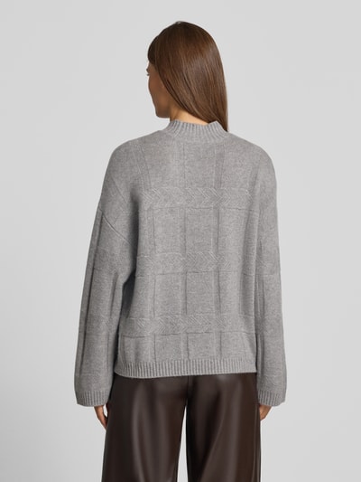 Frauenmodel trägt Oversized Wollpullover mit Kaschmir-Anteil von Emporio Armani in Grau, Strukturmuster, gerippte Abschlüsse, Ganzkörperansicht Rückansicht.