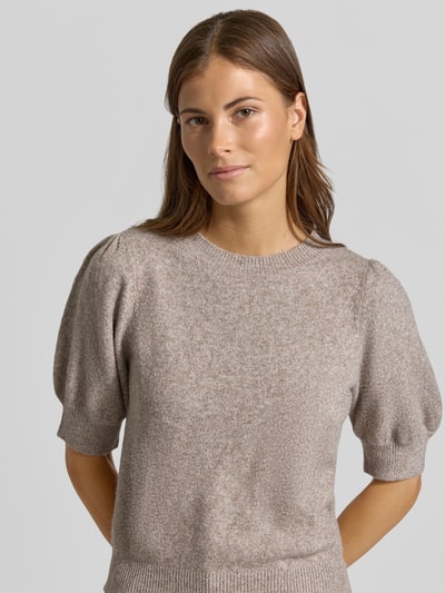 Frauenmodel trägt Regular Fit Pullover mit Puffärmeln von VERO MODA in Beige mit weicher Textur, Nahaufnahme Oberkörper.