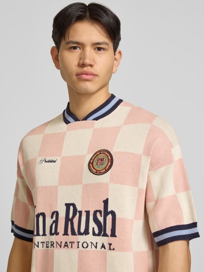 Männermodel trägt Strickshirt mit Label-Stitching Modell 'Victory' von PROHIBITED in Rosa-Creme mit Reine Baumwolle, Relaxed-Fit, Nahaufnahme Oberkörper. Rückenlänge bei Größe M: 66 cm.
