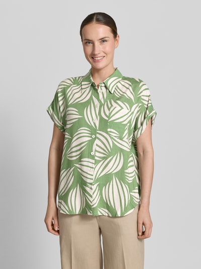 Frauenmodel trägt Bluse aus Viskose-Mix mit Brusttasche von Apricot in Grün mit weißem Print, Knopfleiste, Loose-Fit, Hemdblusenkragen, Leinen-Viskose-Anteil, Ärmel mit fixiertem Aufschlag, Rückenlänge 65 cm, Ärmellänge 20 cm, Ganzkörperansicht von vorne.