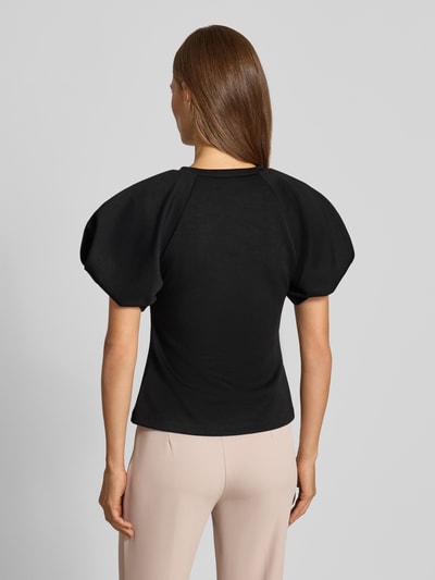 Vrouwenmodel draagt Bluse mit Ballonärmeln van Rinascimento in zwart, Materiaalmix met stretch, getailleerde pasvorm, ruglengte 55 cm, mouwlengte 27 cm, ronde hals, ballonmouwen, Ganzkörperansicht Rückansicht.