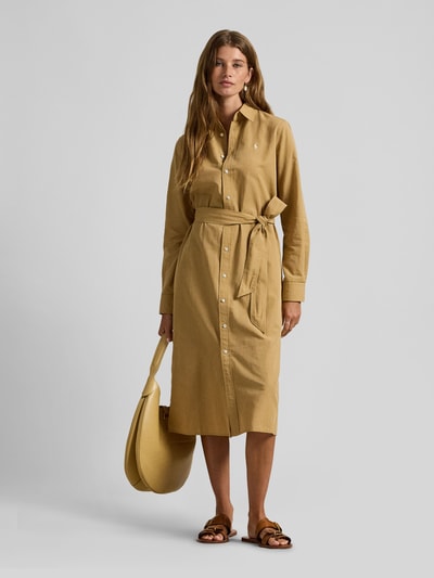 Frauenmodel trägt Hemdblusenkleid aus Baumwoll-Leinen-Mix von Polo Ralph Lauren in Beige, taillierter Schnitt, Hemdblusenkragen, Knopfleiste, Label-Stitching, Taillengürtel, Ganzkörperansicht von vorne.