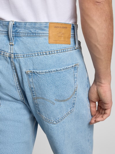 Männermodel trägt Jeans mit 5-Pocket-Design Modell 'ALEX' von JACK & JONES in heller Denim-Optik, Reine Baumwolle, Lockerer-Schnitt, Detailaufnahme Rückansicht.