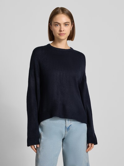 Frauenmodel trägt Relaxed Fit Pullover mit Rundhalsausschnitt Modell 'SIMONI' von ONLY, dunkelblau, glatte Textur, Damen Pullover, Ganzkörperansicht von vorne.