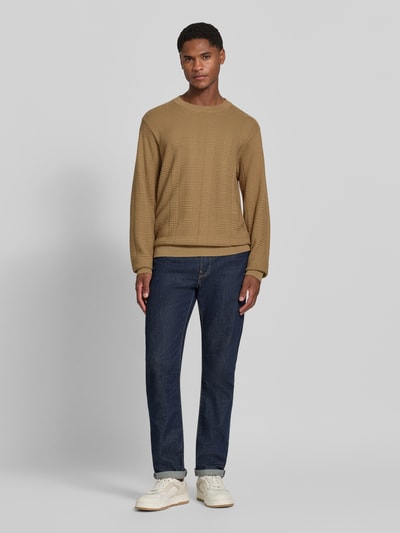 Męski model nosi Regular Fit Pullover aus reiner Baumwolle Modell 'Simoh' von HUGO w kolorze beżowym, faktura żakardowa, kontekst: sweter męski HUGO, całkowite ujęcie z przodu