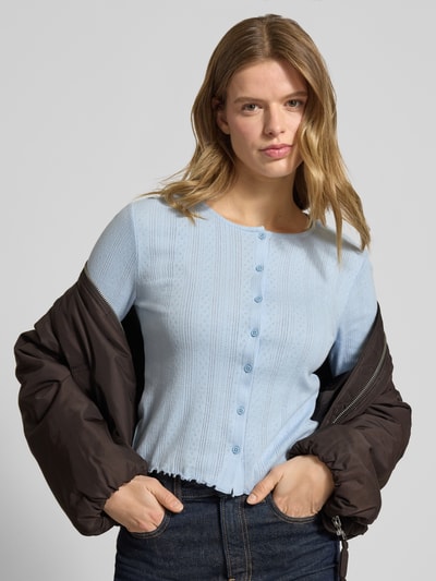 Frauenmodel trägt Slim Fit Cardigan aus Baumwoll-Viskose-Mix Modell 'MARIE' von Pieces, Optik: Unifarben, Muster: Lochstrickmuster, Rundhals, Langarm, Frill an Ärmel- und Rumpfabschluss, einreihige Knopfleiste, Ganzkörperansicht von vorne.