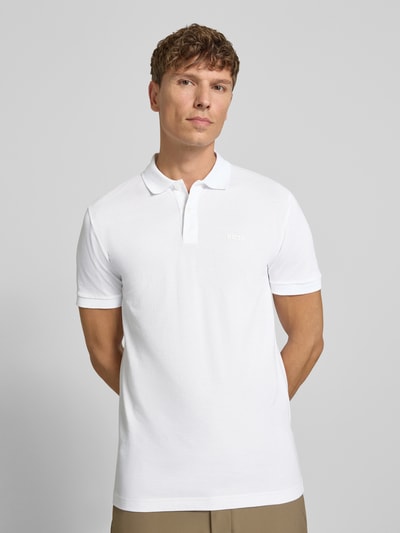 Męski model nosi Regular Fit Poloshirt aus reiner Baumwolle Modell 'PIO 1' von BOSS Green, biała koszulka polo, gładka faktura, Ganzkörperansicht von vorne.